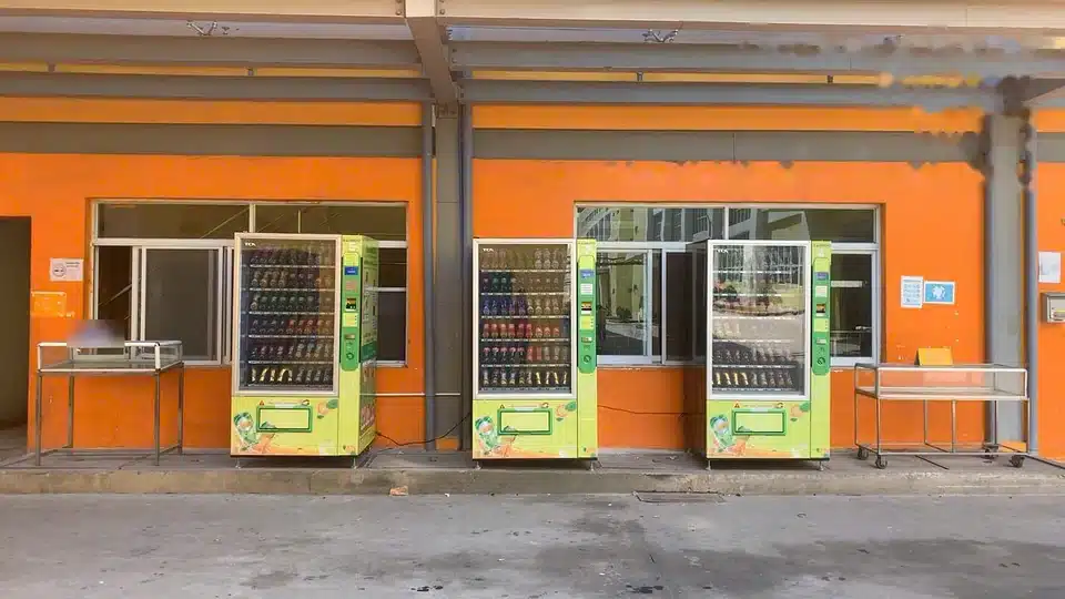 Các máy bán hàng tự động BambooTech đặt thành cụm dọc tường nhà xưởng tại một khu công nghiệp ở Bình Dương (ban ngày)
